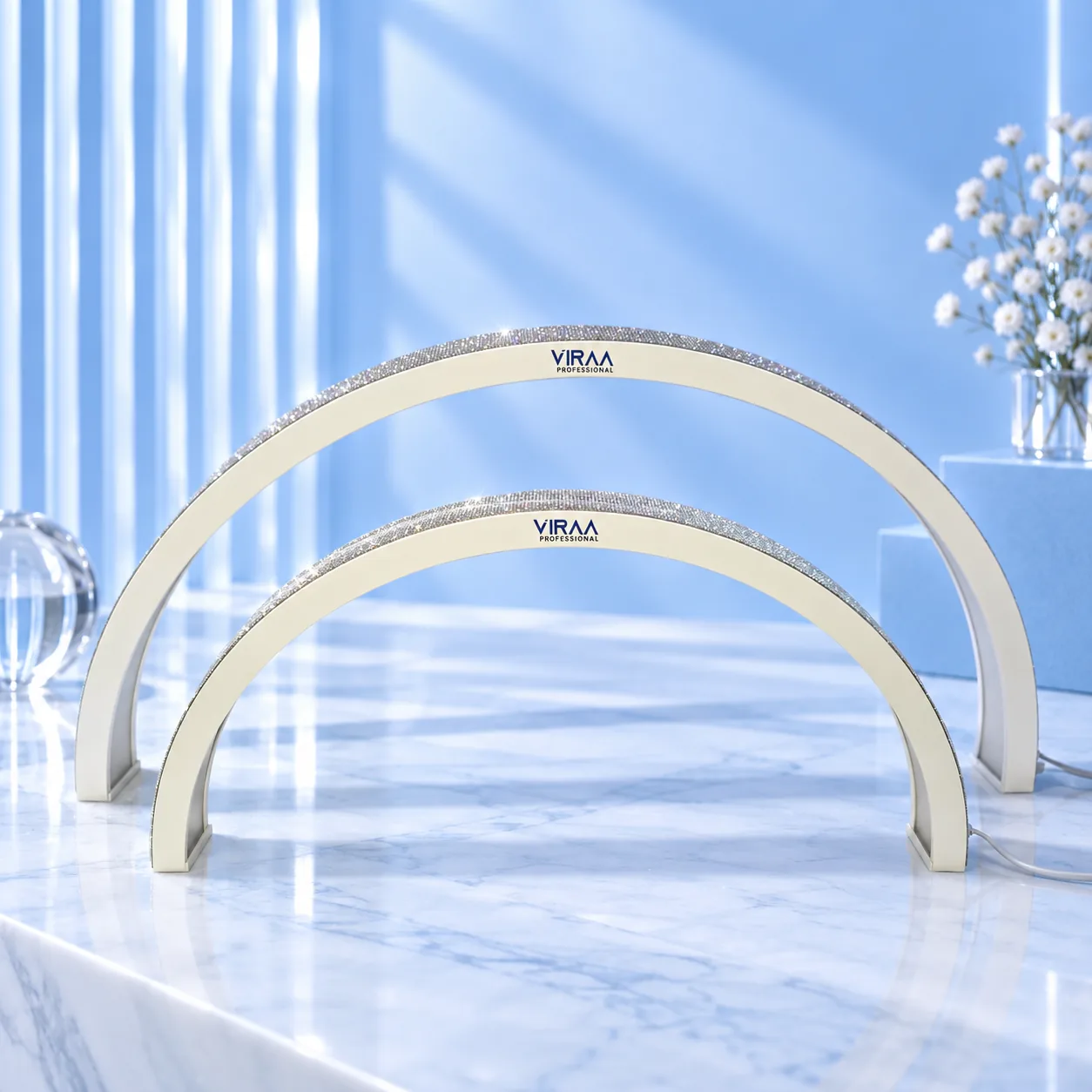 Front view of the white moon-shaped nail table lamps in both sizes on a marble desk